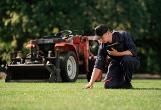 tocando-grama-o-homem-esta-com-um-trator-utilitario-com-cortador-de-grama-e-equipamento-de-aeracao-no-campo